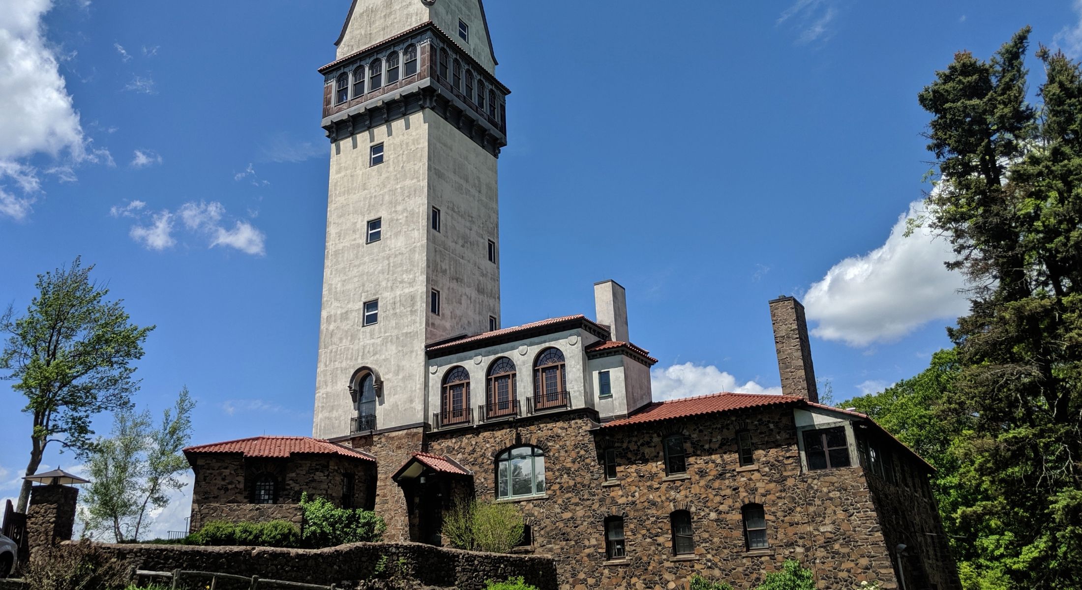 Historic tower and stone building under blue sky.