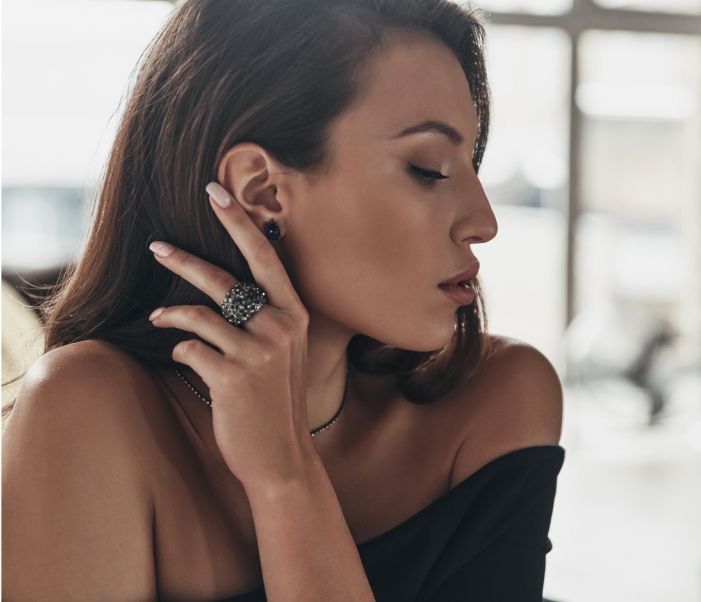 Woman wearing jewelry in profile view.