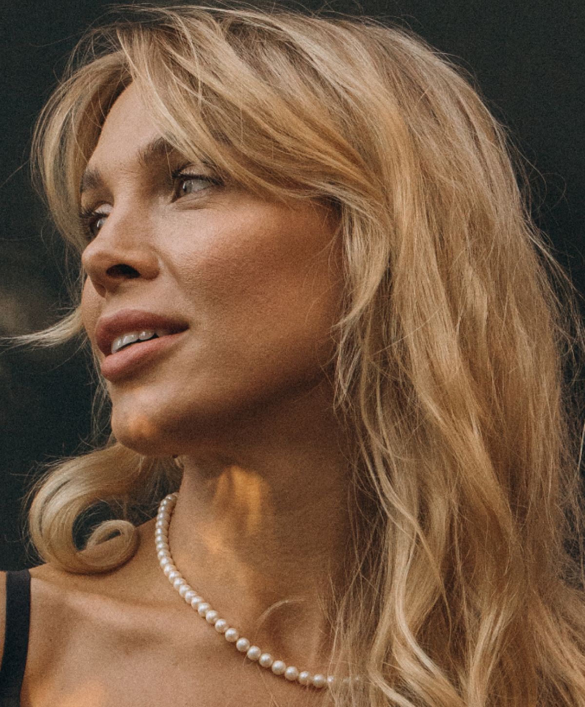 Farmington Renuva model with wavy blonde hair and pearl necklace.