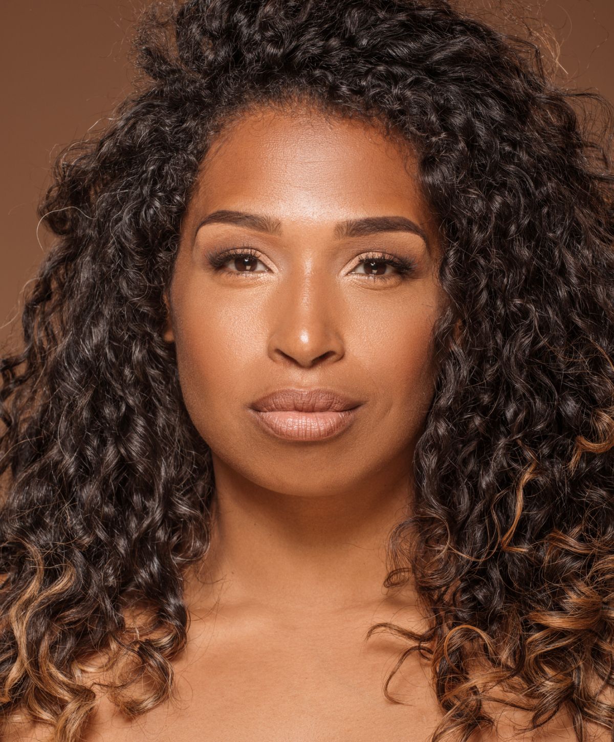 Farmington photofacial model with curly hair and neutral makeup.