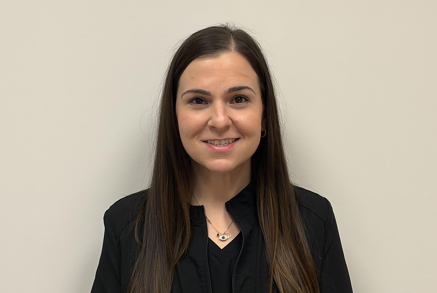 Smiling woman with long dark hair, black top.