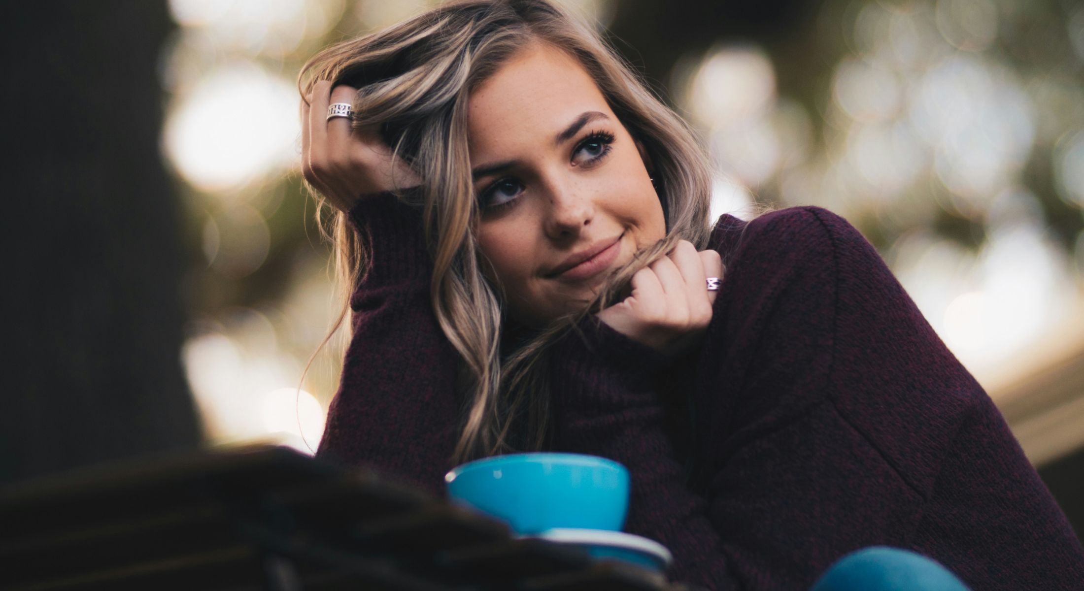 Young woman looking thoughtfully while resting chin.